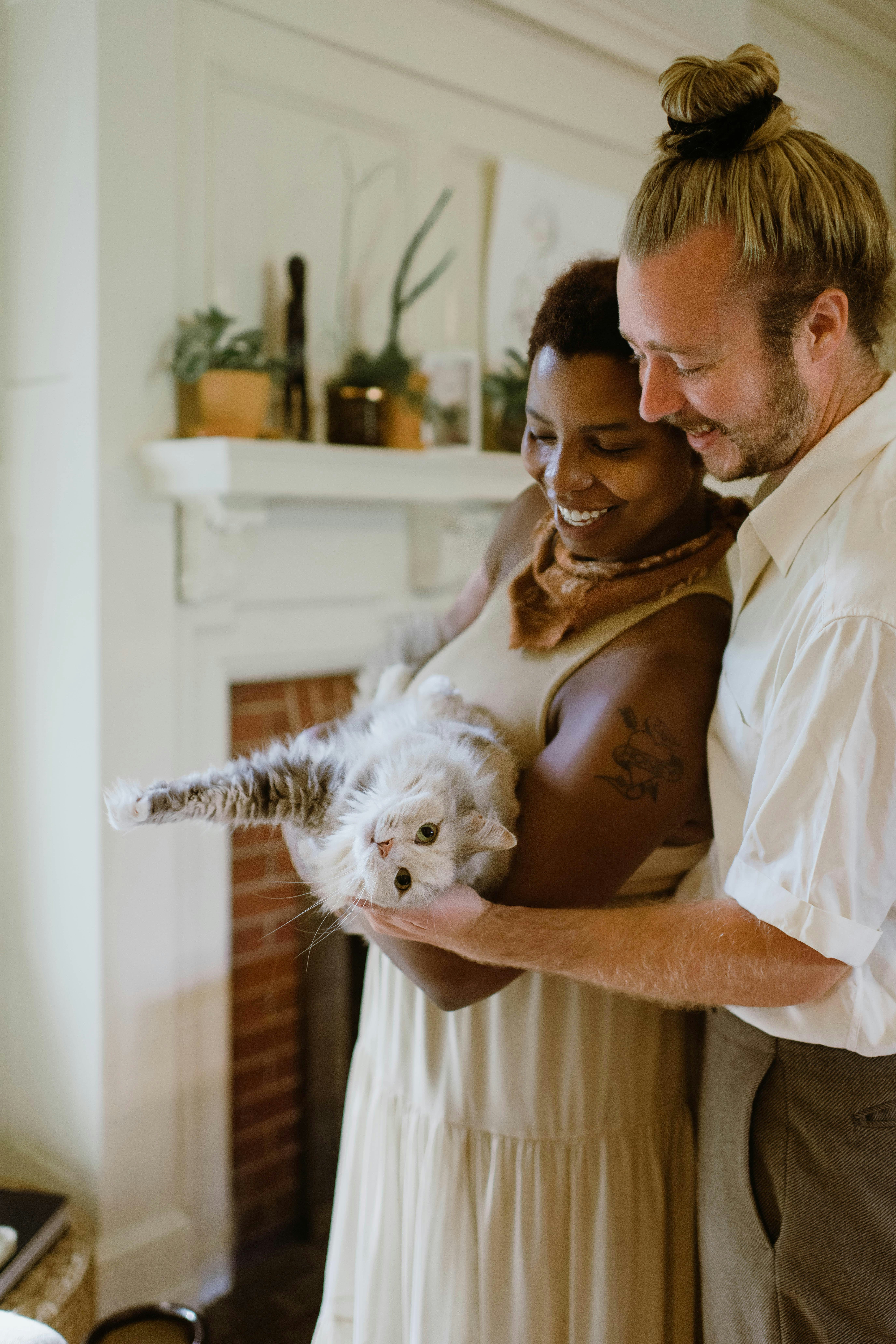This is an image of a black woman holding a cat with her white male partner standing behind her for an article about diverse stock photos for Contently